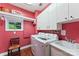 Bright red laundry room with washer, dryer, sink, storage, and window at 314 Center Dr, Davidson, NC 28036