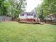 Backyard view featuring the home and deck surrounded by mature trees, providing a serene outdoor space at 318 Chestnut Ave, Kannapolis, NC 28081