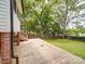 Backyard features a wooden deck overlooking a lush, green lawn and mature trees at 318 Chestnut Ave, Kannapolis, NC 28081