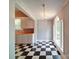 View of the dining room with arched window, checkered flooring, and the kitchen in the background at 318 Chestnut Ave, Kannapolis, NC 28081