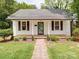 Charming home with a welcoming front porch, beautiful landscaping, and a brick walkway to the front door at 318 Chestnut Ave, Kannapolis, NC 28081