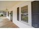 A view along the long, covered front porch that has a wooden floor and the house number on the door at 318 Chestnut Ave, Kannapolis, NC 28081