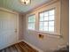Functional mud room with durable laminate flooring, two windows, and access to the exterior at 318 Chestnut Ave, Kannapolis, NC 28081