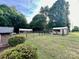 Spacious backyard featuring lush greenery, mature trees, and additional storage sheds at 35 Caldwell Dr, Taylorsville, NC 28681