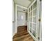 Hallway with wood floors, white wainscoting, and doors with glass panels at 35 Caldwell Dr, Taylorsville, NC 28681