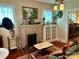 Warm living room with brick fireplace, vintage decor, and hardwood flooring at 401 7Th St, Spencer, NC 28159