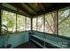 Enclosed back porch with a panoramic view of a green and leafy street with seating at 401 7Th St, Spencer, NC 28159