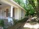Exterior view showing a corner with maroon shutters, overgrown foliage, and a tree at 421 W Cemetery St, Salisbury, NC 28144