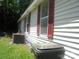 House exterior with white siding and maroon shutters, showcasing a utility area and trash bin at 421 W Cemetery St, Salisbury, NC 28144