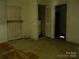 Room with damaged flooring, wood paneled door, a hot water heater, and drab walls at 421 W Cemetery St, Salisbury, NC 28144