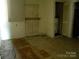 Room with damaged flooring, wood paneled door, a hot water heater, and drab walls at 421 W Cemetery St, Salisbury, NC 28144