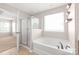 Bright bathroom featuring a soaking tub and separate glass-enclosed shower with a view to the carpeted bedroom at 4352 Haddington Dr, Fort Mill, SC 29707