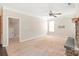 Open living room with neutral carpet, ceiling fan, stone fireplace, and door to the next room at 4352 Haddington Dr, Fort Mill, SC 29707