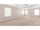 Main bedroom with tray ceiling, carpet, multiple windows, and a ceiling fan at 4352 Haddington Dr, Fort Mill, SC 29707