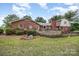 Spacious backyard featuring a wooden deck, brick facade, and lush greenery at 4630 Woodleaf Rd, Salisbury, NC 28147