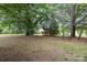 Expansive yard with mature trees and a partial view of the charming brick home at 4630 Woodleaf Rd, Salisbury, NC 28147