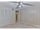 Bedroom featuring wood-panelled walls, carpet flooring, and a ceiling fan at 466 Shiloh Church Rd, Hickory, NC 28601