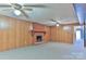 Spacious living room with cozy brick fireplace, ceiling fans, and wood paneling at 466 Shiloh Church Rd, Hickory, NC 28601