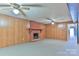 Large living room with wood paneling, brick fireplace, and ceiling fans at 466 Shiloh Church Rd, Hickory, NC 28601