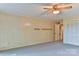 Open living room with wood-panelled walls, open shelving, and ceiling fan at 466 Shiloh Church Rd, Hickory, NC 28601