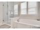 Elegant bathroom features a walk-in shower with glass doors and a luxurious soaking tub with fixtures at 4689 Kingswood Dr, Indian Land, SC 29707