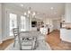Open-concept dining area with wood floors, stylish lighting fixture, and views into kitchen and living areas at 4689 Kingswood Dr, Indian Land, SC 29707
