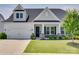 Charming home featuring a well-manicured lawn, white siding, stone accents, and a covered front porch at 4689 Kingswood Dr, Indian Land, SC 29707
