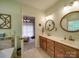 Bathroom featuring double sinks, decorative round mirrors, updated lighting, and neutral colors at 4715 Lenden Hall Ct, Gastonia, NC 28056