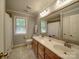 Well-lit bathroom features a double sink vanity with a large mirror and tiled floor at 4715 Lenden Hall Ct, Gastonia, NC 28056