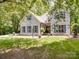 Stunning white brick home featuring lush greenery, blue shutters, and a well-manicured lawn at 4715 Lenden Hall Ct, Gastonia, NC 28056