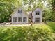 Beautiful white brick home with blue shutters, manicured lawn, and an American flag at 4715 Lenden Hall Ct, Gastonia, NC 28056