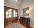 Elegant foyer with wood floors, stylish dresser, mirror, and double doors at 4715 Lenden Hall Ct, Gastonia, NC 28056