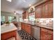 Charming kitchen with wooden cabinets, brick backsplash, stainless steel appliances, and a view to the breakfast area at 4715 Lenden Hall Ct, Gastonia, NC 28056