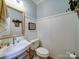 Charming powder room with a white vanity, gold fixtures, wainscoting, and wooden floors at 4715 Lenden Hall Ct, Gastonia, NC 28056