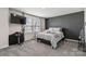 Nicely staged bedroom with dark accent wall, soft carpet, and large windows at 5121 Ennisworth Ln, Charlotte, NC 28214