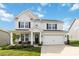 Charming two-story home featuring a well-manicured lawn, a covered porch, and a two car attached garage at 5121 Ennisworth Ln, Charlotte, NC 28214