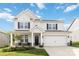 Charming two-story home featuring a well-manicured lawn, a covered porch, and a two car attached garage at 5121 Ennisworth Ln, Charlotte, NC 28214