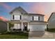 Charming two-story home featuring a well-manicured lawn, a covered porch, and a two car attached garage at 5121 Ennisworth Ln, Charlotte, NC 28214