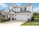 Charming two-story home featuring a well-manicured lawn, a covered porch, and a two car attached garage at 5121 Ennisworth Ln, Charlotte, NC 28214