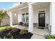 Inviting front porch with stone accents, comfortable seating, and a stylish front door at 5121 Ennisworth Ln, Charlotte, NC 28214