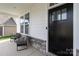 Inviting front porch with stone accents, comfortable seating, and a stylish front door at 5121 Ennisworth Ln, Charlotte, NC 28214