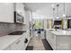 Modern kitchen featuring white cabinets, stainless steel appliances, and an open layout to the dining area at 5121 Ennisworth Ln, Charlotte, NC 28214