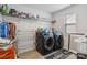Well-equipped laundry room featuring modern washer and dryer, shelving, and a window at 5121 Ennisworth Ln, Charlotte, NC 28214