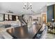 Open-concept living area showcasing modern decor, a dining table, and a staircase with decorative wallpaper at 5121 Ennisworth Ln, Charlotte, NC 28214