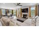 Bright living room with a fireplace, large windows with bright yellow curtains, and a large sectional sofa at 5121 Ennisworth Ln, Charlotte, NC 28214