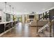 Open-concept living room with hardwood floors, fireplace, and kitchen bar for a modern design at 5121 Ennisworth Ln, Charlotte, NC 28214