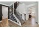Elegant staircase with decorative wallpaper, a modern chandelier, and hardwood flooring at 5121 Ennisworth Ln, Charlotte, NC 28214