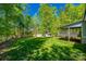 A spacious backyard with a storage shed, bordered by trees and wooden fencing, provides ample space for outdoor activities at 7435 Hammond Dr, Charlotte, NC 28215