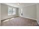 Bedroom with plush carpet, white trim, neutral paint, and a bright window at 7435 Hammond Dr, Charlotte, NC 28215