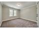 Well-lit bedroom with plush carpeting, white trim, and a large window at 7435 Hammond Dr, Charlotte, NC 28215